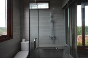 a bathroom with a glass shower with a toilet at Ohmmstay - Rumah Pendopo in Tanjungtirto +139 photos