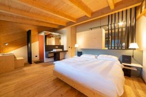 1 dormitorio con 1 cama blanca grande y escritorio en Maso Torbiera- Rural and Mountain lodging en Fiavè