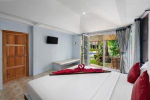 een slaapkamer met een bed met een rode strik erop bij Avocado Koh Samui in Bophut 