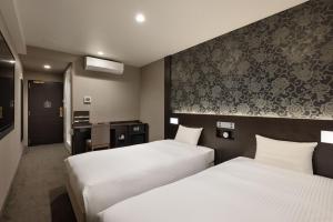 a hotel room with two beds and a bathroom at the b namba-kuromon in Osaka