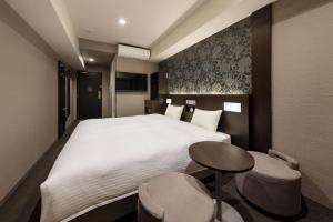 a hotel room with a large bed and a table at the b namba-kuromon in Osaka