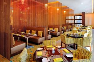 a dining room with tables and chairs and a restaurant at Courtyard by Marriott World Trade Center, Abu Dhabi in Abu Dhabi