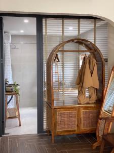 a room with a closet with a wooden table and a mirror at Hue Sweethouse 2 Homestay in Hue