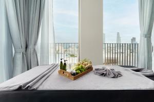 a basket of fruit on a bed with a window at M City Hotel Saigon in Ho Chi Minh City