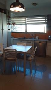 a kitchen with a table and chairs in a kitchen at Edificio frente Club Tenis. in Cochabamba