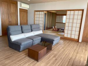 uma sala de estar com um sofá e uma mesa em Support Inn Minami-Chita Annex Hamachaya em Minamichita