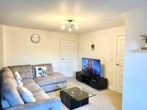 a living room with a couch and a flat screen tv at Balne Mill Grove in Wakefield