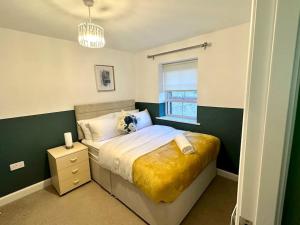 a bedroom with a bed with a yellow blanket at Balne Mill Grove in Wakefield