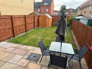 a patio with a table and chairs and a fence at Balne Mill Grove in Wakefield