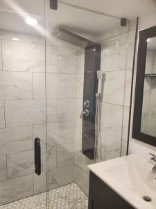 a bathroom with a glass shower with a sink at Suite ravissante MYD in Milton