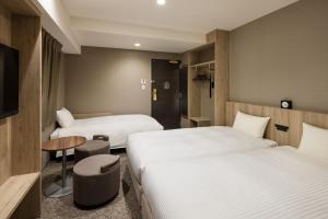 a hotel room with two beds and a table at the b namba-kuromon in Osaka