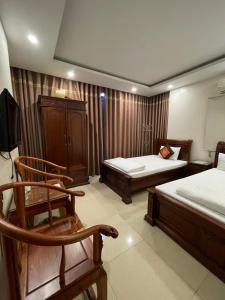 a room with two beds and a chair in it at Phúc Quý Hotel - 149B Lê Duẩn - by Bay Luxury in Hanoi