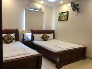 1 dormitorio con 2 camas y ventilador en la pared en Phúc Quý Hotel - 149B Lê Duẩn - by Bay Luxury, en Hanói