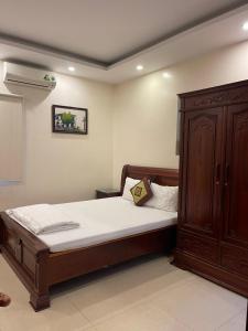 1 dormitorio con 1 cama y armario de madera en Phúc Quý Hotel - 149B Lê Duẩn - by Bay Luxury, en Hanói