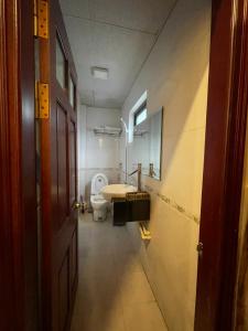 a bathroom with a toilet and a sink and a door at Phúc Quý Hotel - 149B Lê Duẩn - by Bay Luxury in Hanoi