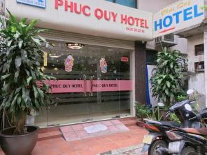 un negozio di fronte a un hotel con una moto parcheggiata fuori di Phúc Quý -149B Lê Duẩn HN - by BAY LUXURY a Hanoi