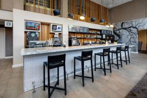 a bar with black stools in a restaurant at Courtyard Austin-University Area in Austin