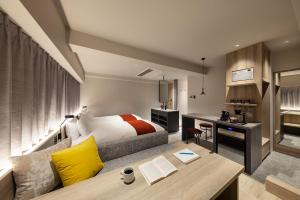 a hotel room with a bed and a desk and a desk at the b namba-kuromon in Osaka