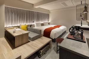 a hotel room with a bed and a couch at the b namba-kuromon in Osaka