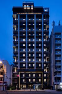 a tall blue building with lights on top of it at the b namba-kuromon in Osaka
