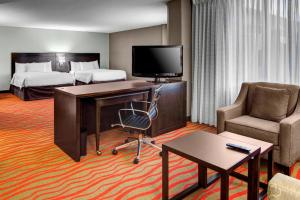 a hotel room with a bed and a desk with a computer at Courtyard by Marriott St. Cloud in Saint Cloud