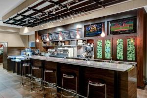 a bar in a restaurant with stools and televisions at Courtyard by Marriott St. Cloud in Saint Cloud