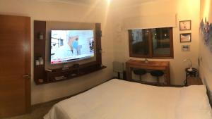 um quarto de hotel com uma cama e uma televisão em Departamento residencial Valle Nevado em Lo Barnechea
