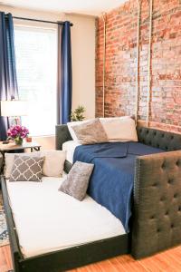 uma cama e um sofá num quarto com uma parede de tijolos em Cityscape 2 -Sleep 7 em Chattanooga