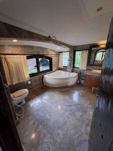 y baño grande con bañera y aseo. en Dzawani Villa Ubud, en Tampaksiring