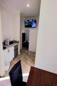 a kitchen with a table and a tv on a wall at Albury Central Motel in Albury