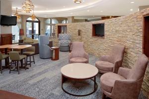 a lobby with chairs and tables and a brick wall at Courtyard by Marriott Houma in Houma