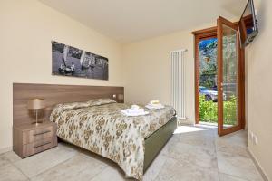 マルチェージネにあるCallaLillyJardinのベッドルーム1室(ベッド1台付)、スライド式ガラスドアが備わります。