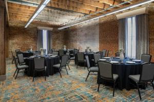 a conference room with tables and chairs and brick walls at Courtyard by Marriott New Orleans Warehouse Arts District in New Orleans