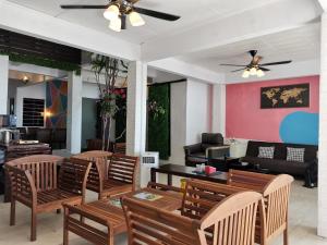 restauracja z krzesłami i stołami oraz wentylatorem sufitowym w obiekcie Greenage Seaview Bay Villa with stunning sunset w mieście Putatan