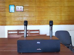 un router en una mesa de madera con dos micrófonos en Greenage Seaview Bay Villa with stunning sunset en Putatan
