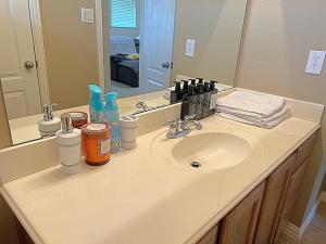 um balcão de casa de banho com um lavatório e um espelho em Cozy luxury home em Grand Prairie