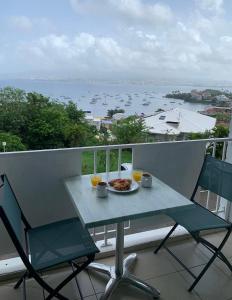 une table avec une assiette de nourriture sur un balcon dans l'établissement Studio Bod’Lanmè - Trois îlets, à Les Trois-Îlets