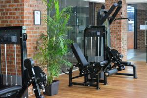 a gym with cardio equipment in a brick wall at M-Stay Hostel in Chemor