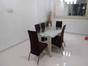 a dining room table with black chairs and a mirror at Homestay Legacy Yumai Kuala Rompin in Kuala Rompin