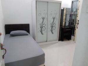 1 dormitorio con 1 cama y puerta corredera en Homestay Legacy Yumai Kuala Rompin en Kuala Rompin