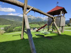 um parque infantil com um baloiço e um gazebo em Hefenscherbauer em Annaberg im Lammertal