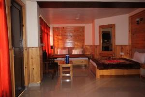 1 dormitorio con 2 camas, escritorio y mesa en Vella Marina Group of hotels Mcleodgunj, en Dharamshala