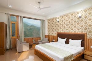 a bedroom with a bed and a large window at Vella Marina Group of hotels Mcleodgunj in Dharamshala