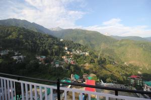 uma vista a partir de uma varanda de uma cidade nas montanhas em Vella Marina Group of hotels Mcleodgunj em Dharamshala