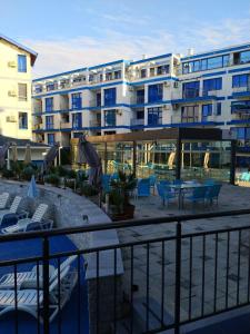 a hotel with a swimming pool and a building at Pomorie Direkt am Pool in Pomorie