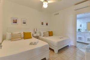 2 camas blancas en una habitación con ventana en New! Lovely And Spacious Fully Equipped Condo In Cap Cana en Punta Cana