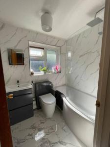 ein Badezimmer mit einer Badewanne, einem WC und einem Waschbecken in der Unterkunft Harbour view in Cowes