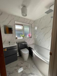 een badkamer met een bad, een toilet en een wastafel bij Harbour view in Cowes