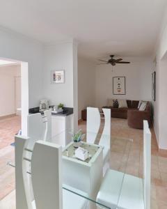 a living room with white furniture and a ceiling fan at New! Lovely And Spacious Fully Equipped Condo In Cap Cana in Punta Cana