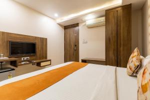 una camera d'albergo con letto e TV di FabHotel Bentree a Bhopal